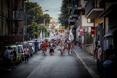 Parade on street amidst buildings in city