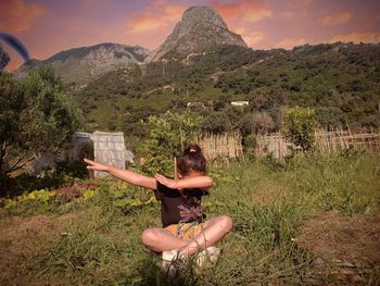 Rear view of young woman against mountain range