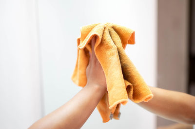 Cropped hands of woman holding gift against white background