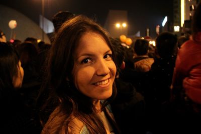 Portrait of young woman amidst crowd celebrating new year eve