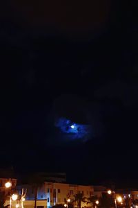 Low angle view of illuminated buildings against sky at night