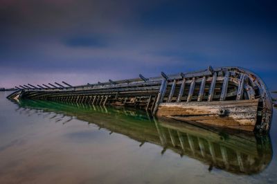 Abandoned boat in lake against sky