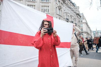 Woman photographing with mobile phone in city