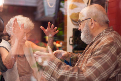 Close-up of people seen through glass window