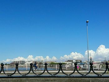 Bicycles on railing against blue sky