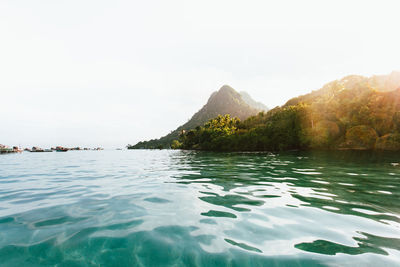 Scenic view of sea and mountains against clear sky