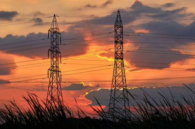 Low angle view of silhouette electricity pylon against romantic sky