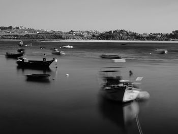 Boats in sea against clear sky
