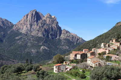 Houses on mountain against sky