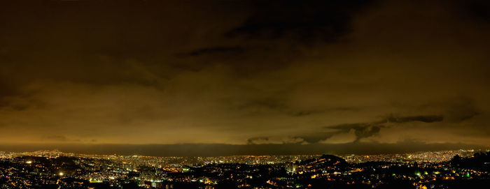 Illuminated cityscape against sky at night