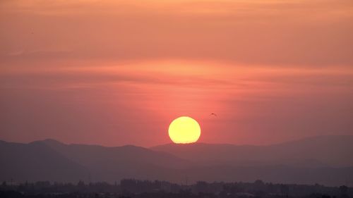 Scenic view of silhouette mountains against romantic sky at sunset