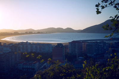 Scenic view of sea and buildings against clear sky