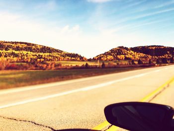 Close-up of highway by road against sky