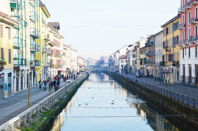 Canal amidst city against sky