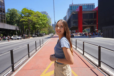 Portrait of young woman standing in city