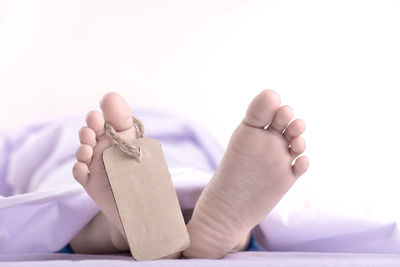 Low section of man lying on bed