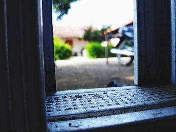 Close-up of metal railing by window