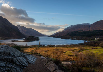 Scenic view of lake by mountains against sky