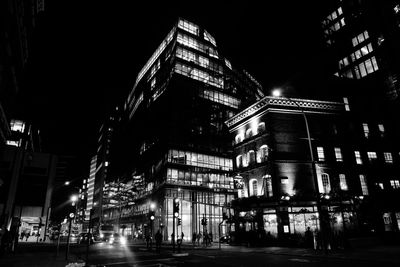 Low angle view of illuminated buildings in city at night