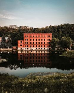 Reflection of building in lake against sky