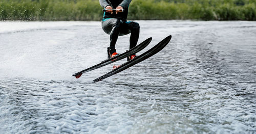 Low section of person waterskiing on water