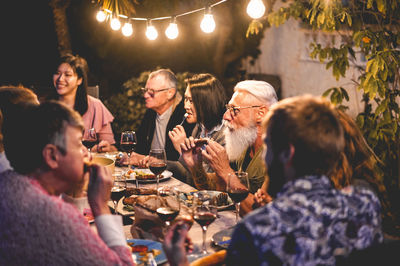 Friends having dinner party at backyard