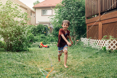 Full length of boy playing in yard against building