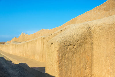 Adobe wall of old ruin during sunny day