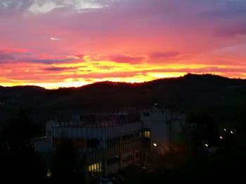 Houses in town against sky at sunset