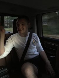 Portrait of young man sitting in car