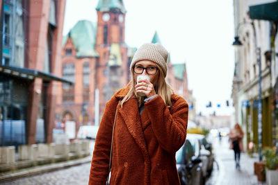 Woman at city street with coffee cup