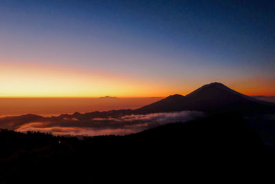 Scenic view of silhouette mountains against romantic sky at sunset