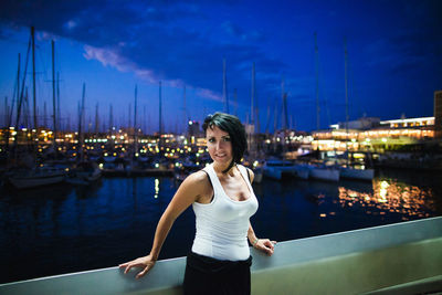 Portrait of woman standing in boat against sky at night