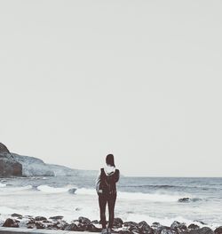 Man standing on beach against clear sky