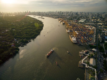 Aerial view of cityscape by river during sunset