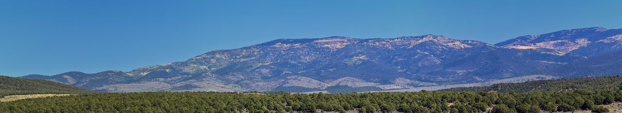 Scenic view of mountains against clear blue sky