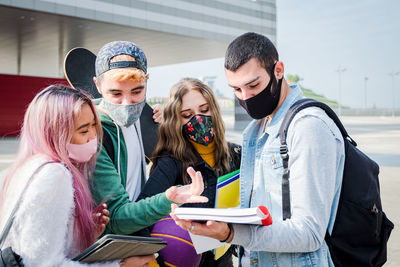 Rear view of two women sitting on mobile phone