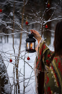 Woman holding christmas tree during winter