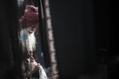 Bearded senior man seen through window