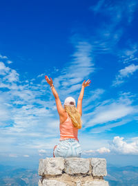 Young girl sitting on a stone with a beautiful view from the top of mont ventoux