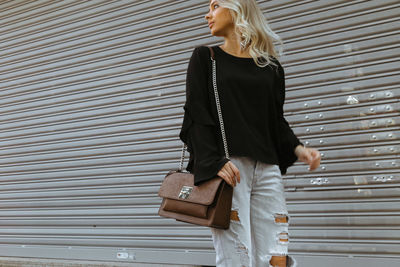 Full length of woman standing against the wall