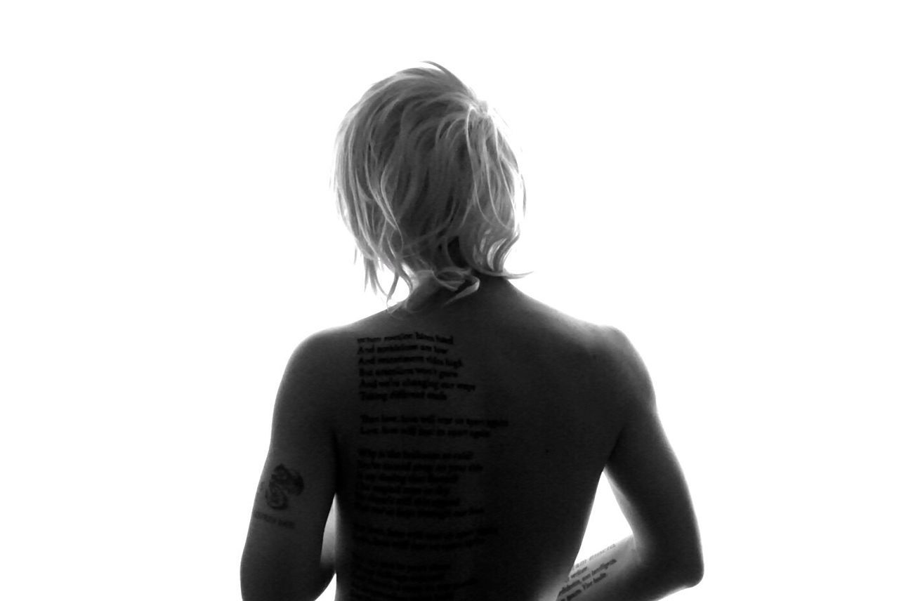 REAR VIEW OF SHIRTLESS WOMAN STANDING ON WHITE BACKGROUND