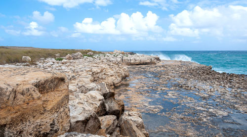 Scenic view of rocks on beach against sky