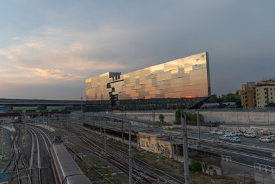 Train at railroad station in city against sky