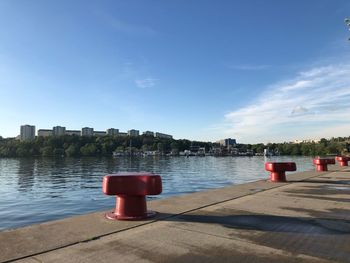 Red light on river in city against blue sky