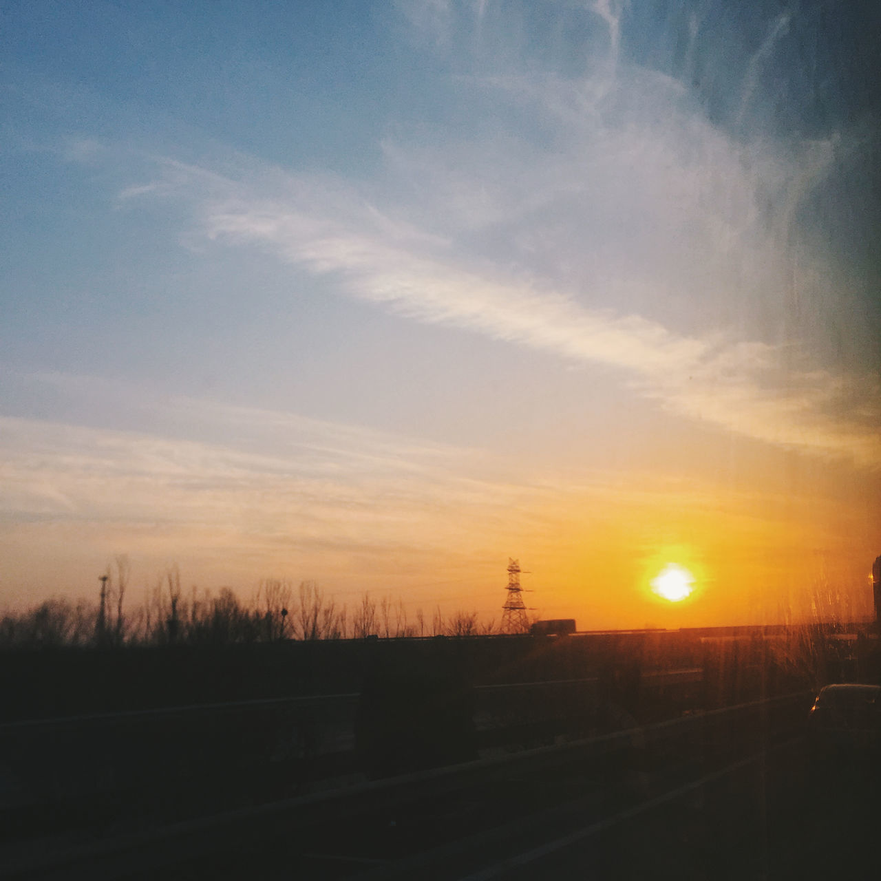 sunset, sun, orange color, silhouette, sky, scenics, landscape, tranquil scene, tranquility, beauty in nature, nature, sunlight, idyllic, cloud - sky, road, field, transportation, outdoors, sunbeam, no people