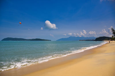 Scenic view of beach against blue sky