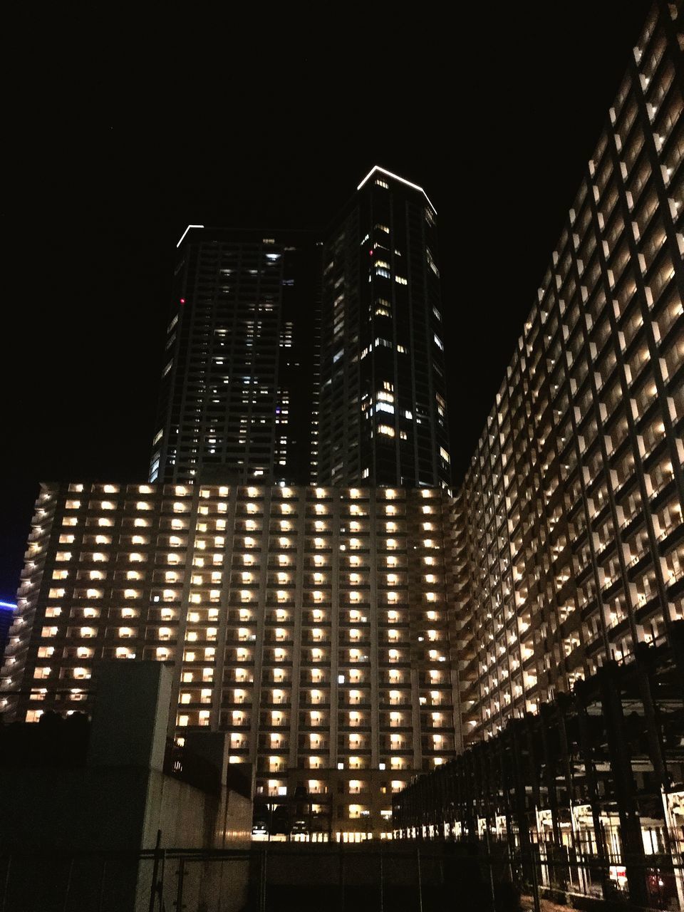 LOW ANGLE VIEW OF ILLUMINATED SKYSCRAPERS AGAINST SKY