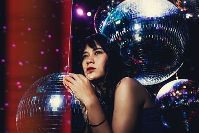 Young woman with disco balls in nightclub