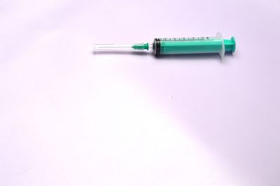 Close-up of syringe on white background